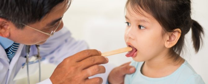 a doctor examining a child who has enlarged tonsils
