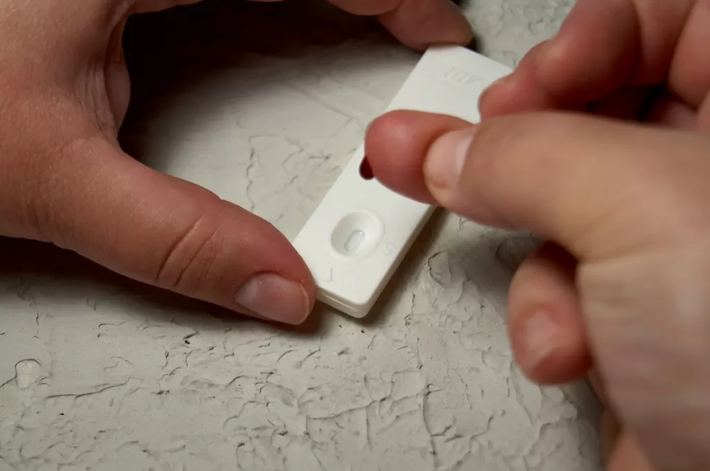 HIV self-test on finger with a drop of blood