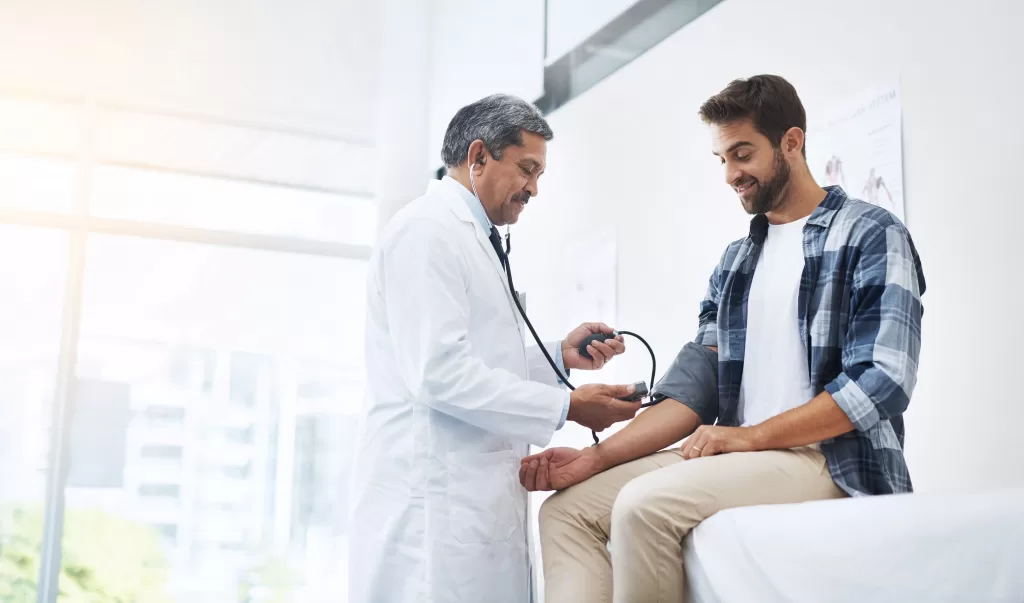 Man in doctors office consulting medical professional