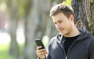 Serious man using a smart phone to speak to an online doctor